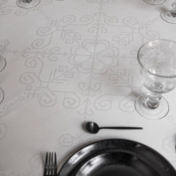 Balts žakarda austs galdauts ar mežģīni apaļam galdam ar latvju rakstu spēka zīmēm ar Saules mandalu